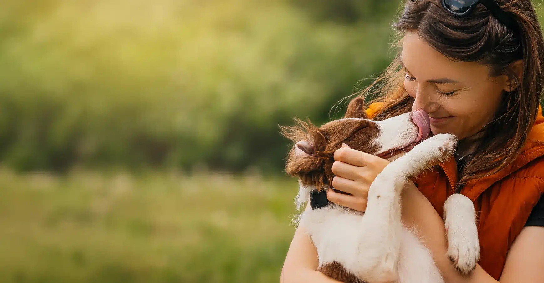 Woman hugging her dog affectionately outdoors, illustrating the human-canine bond